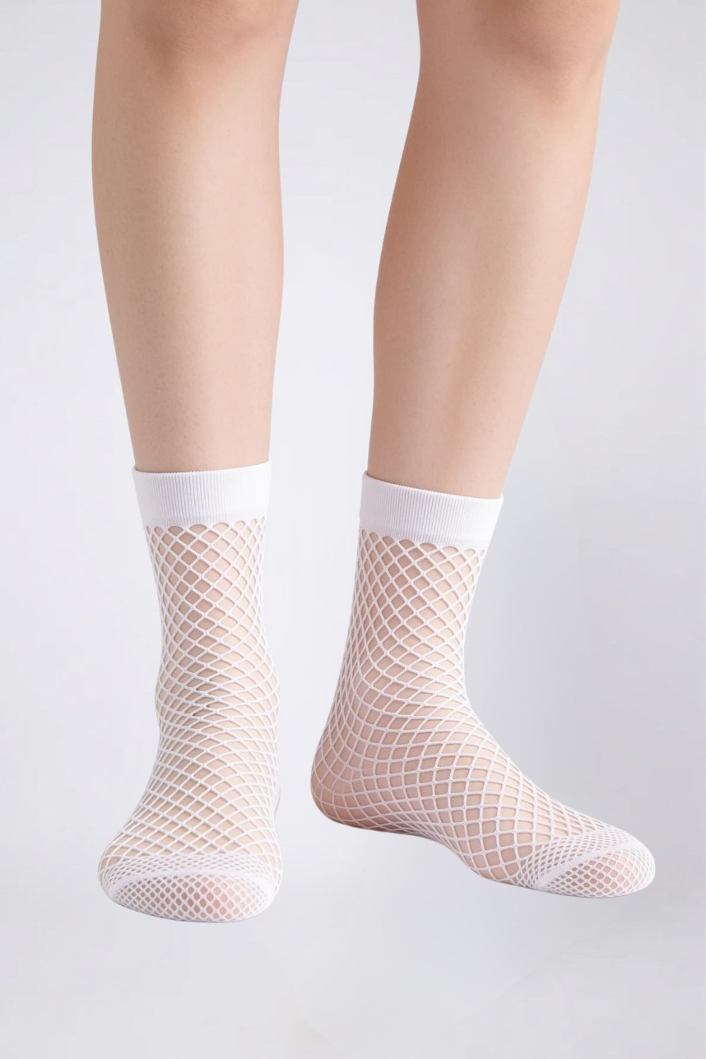Model wearing sheer fishnet ankle stockings in white