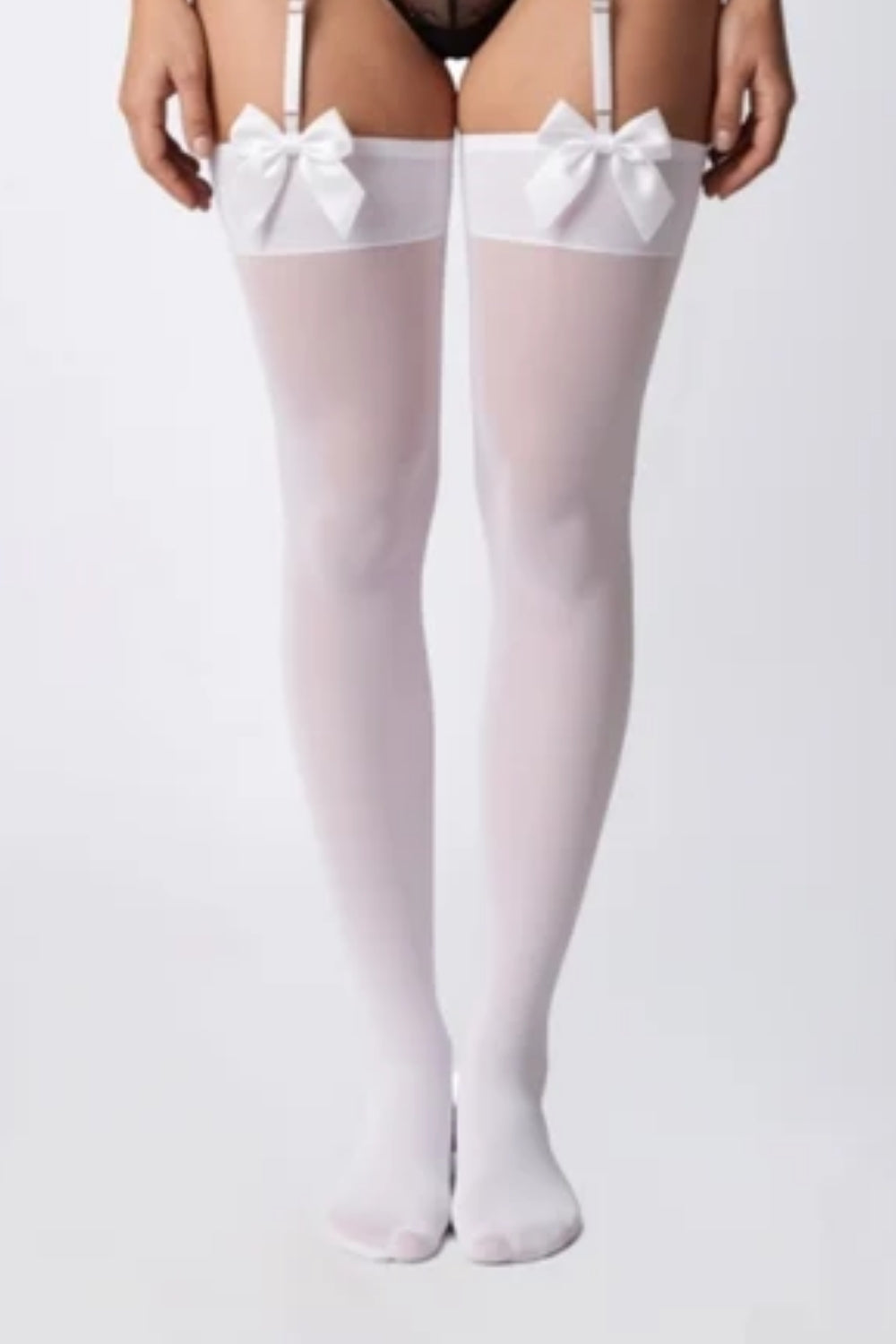 Model wearing sheer bow finish thigh-high stockings in white
