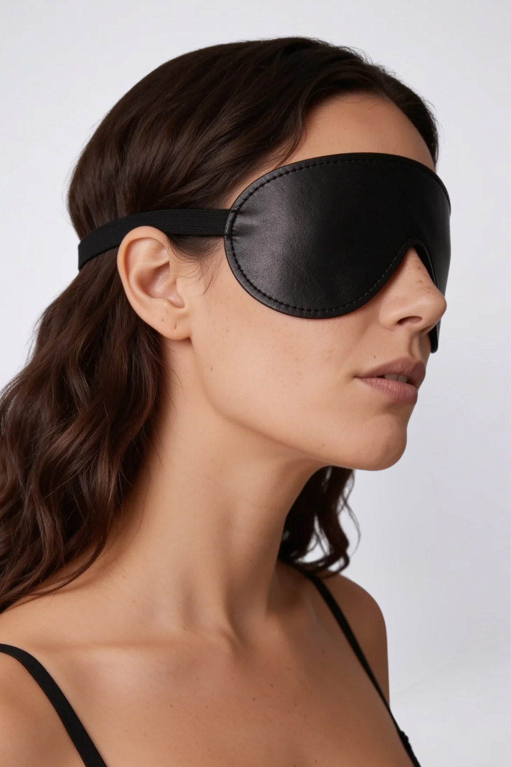 Model wearing contoured grain finish eye mask in black, alternate view