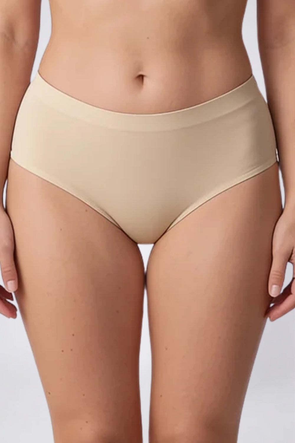 Model wearing laser-cut seamless brief in sand