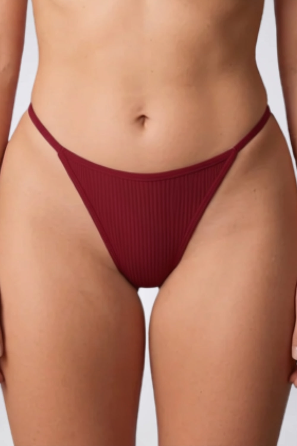 Model wearing ribbed minimalist thong in red