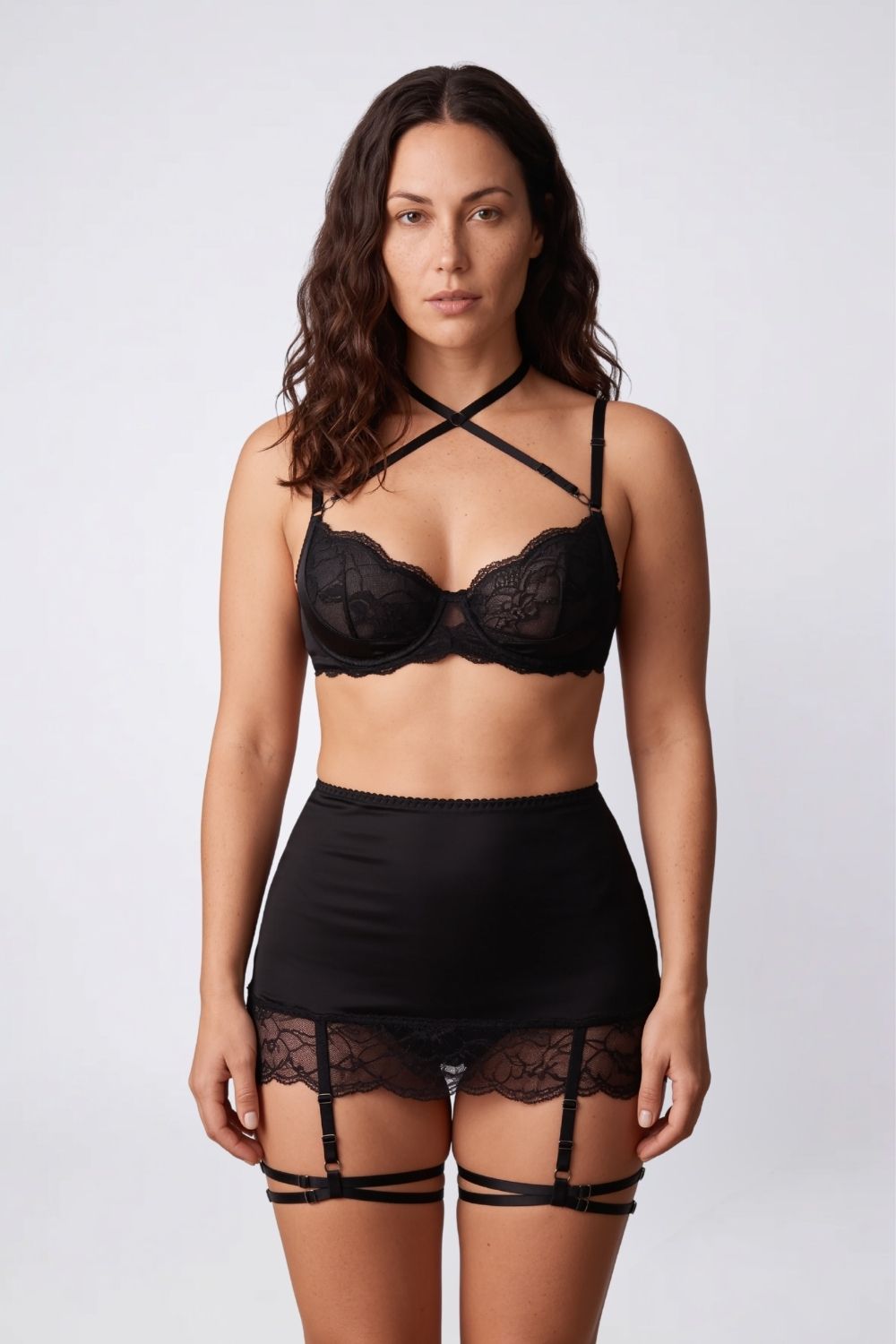 Model wearing satin lace garter three-piece lingerie set in black