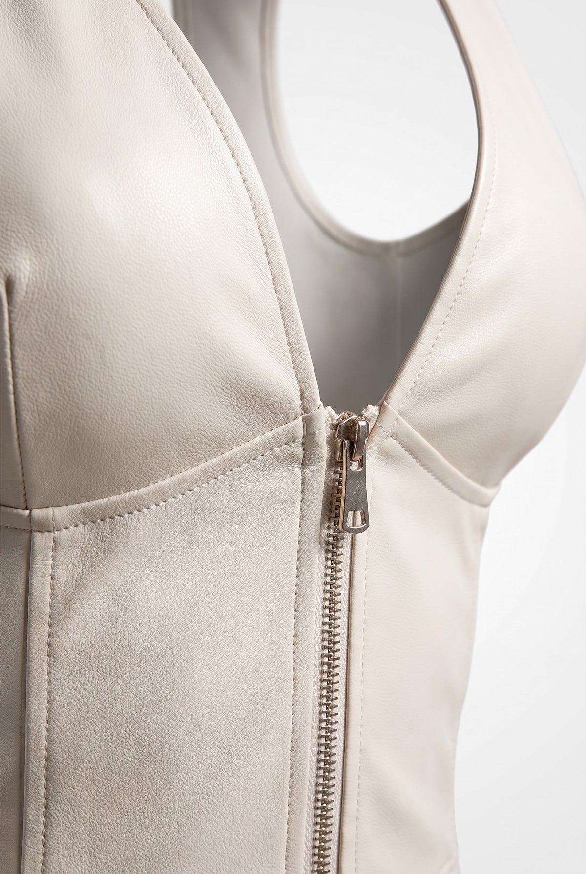 Close-up of the plunge neckline and zip of the grain finish a-line dress in white