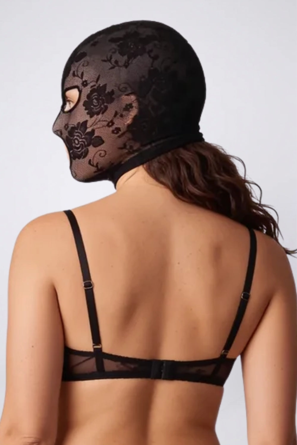 Model wearing floral lace cutout head stocking in black, back view