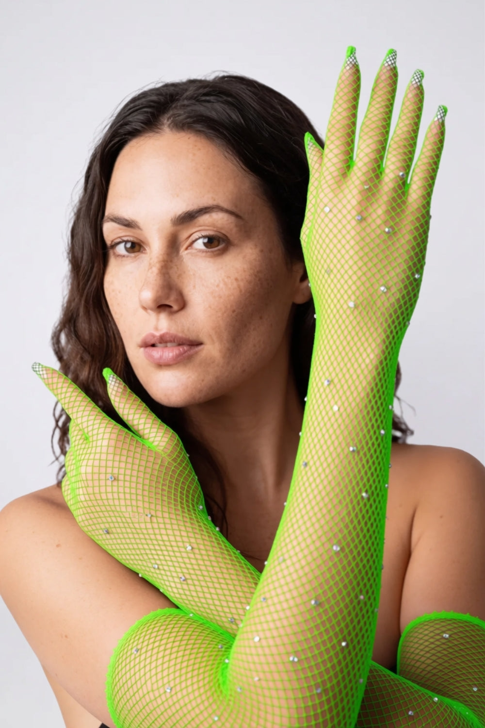 Model wearing rhinestone fishnet gloves in green, alternate view