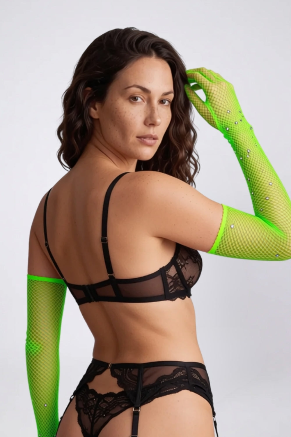 Model wearing rhinestone fishnet gloves in green, alternate view