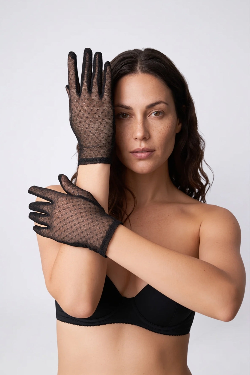 Model wearing sheer dotted mesh gloves in black