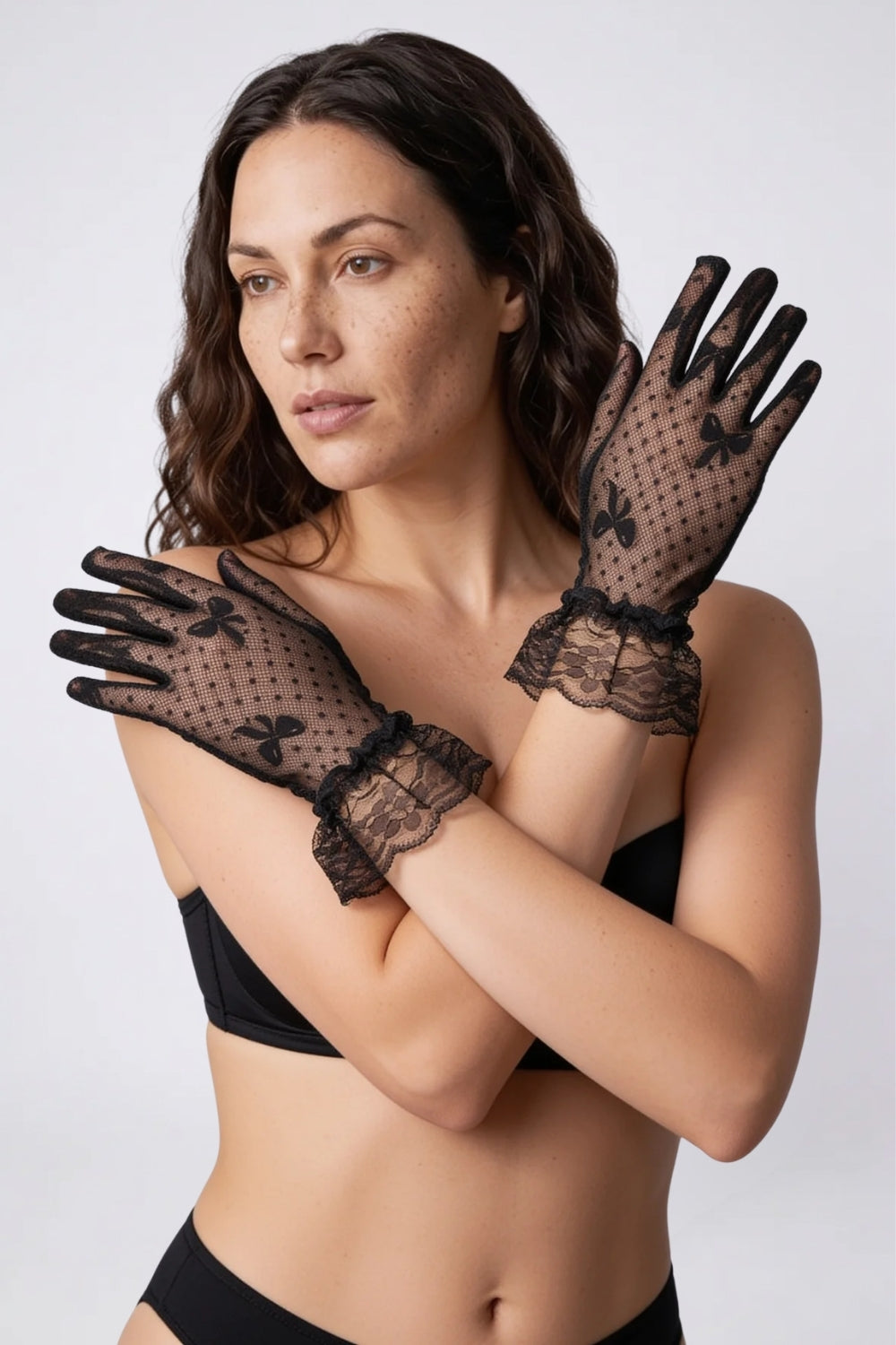 Model wearing sheer lace ruffle cuff gloves in black