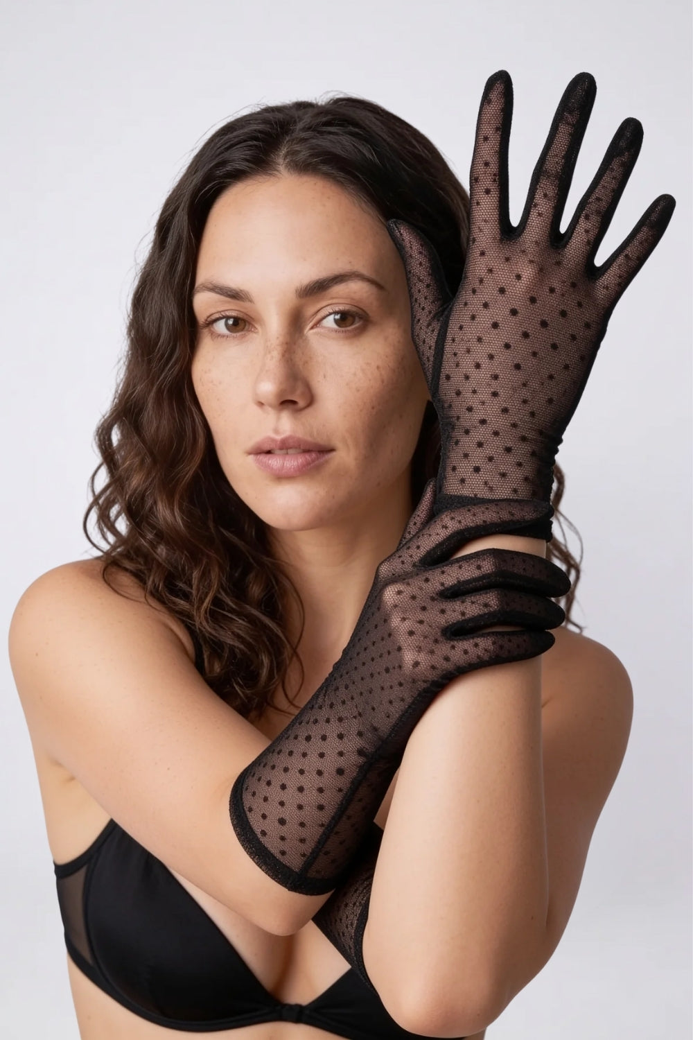 Model wearing sheer polka dot mesh gloves in black