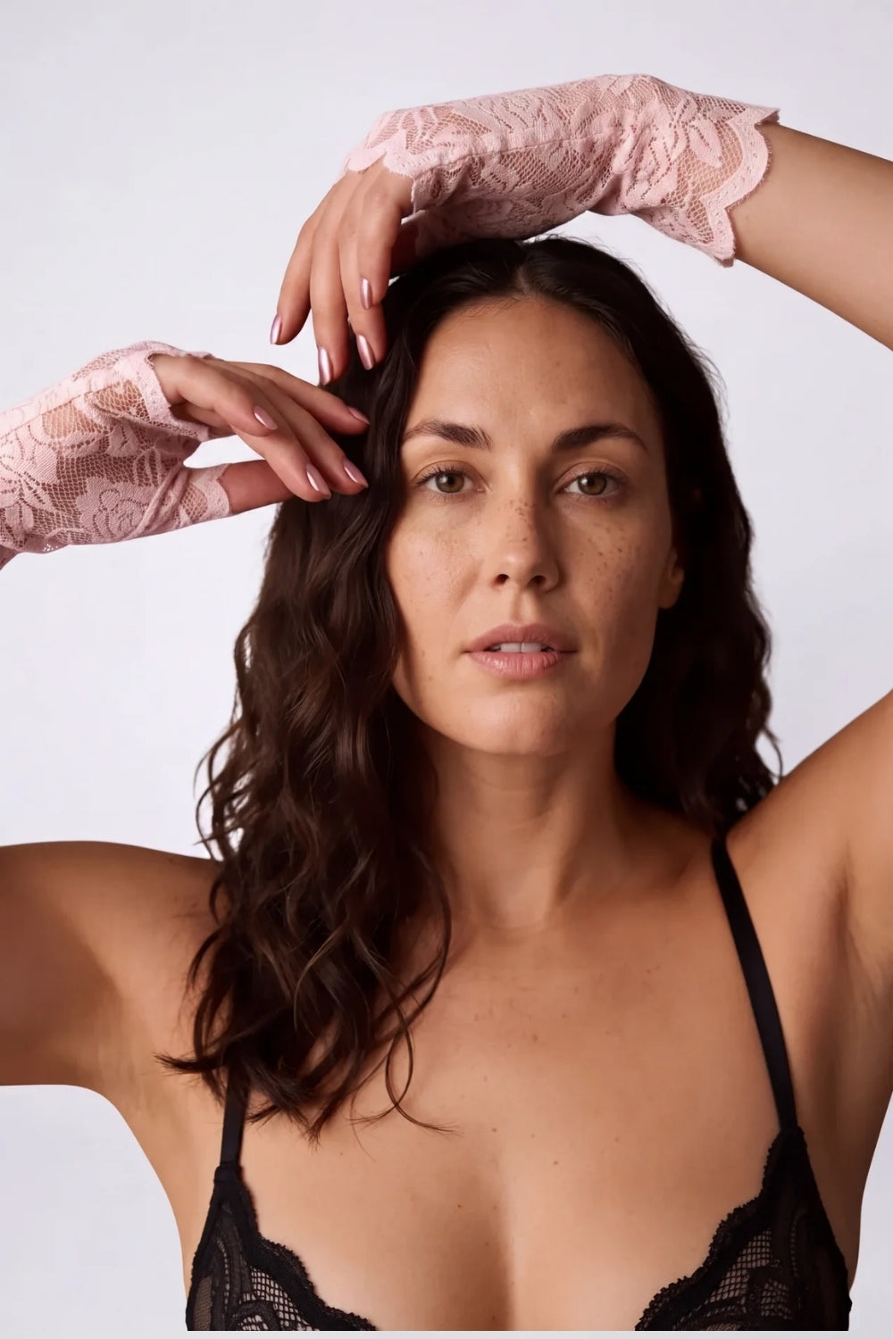 Model wearing sheer rose lace fingerless gloves in pink, alternate view