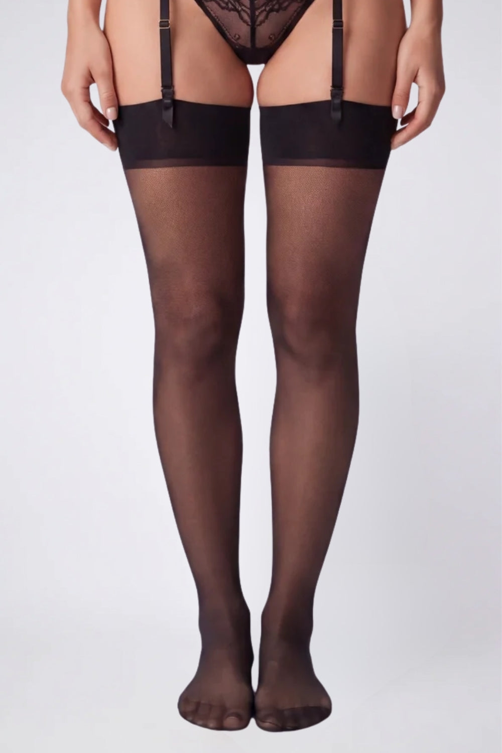 Model wearing sheer silky finish thigh-high stockings in black